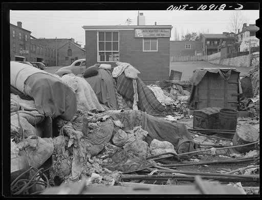 Lancaster, Pennsylvania. Everyone was asked to dump his scrap in a vacant lot at the center of town. It was then bought by a junk man and salvaged. The sign indicated that junk men are short of help