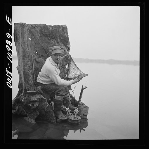 Lancaster County, Pennsylvania. Fishing for salmon on the Susquehanna River at 6 p.m. This man is a state supervisor of highways. In his time off late in the afternoon he fishes with a bottle of hard cider beside him