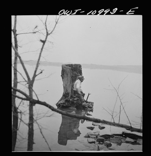 Lancaster, Pennsylvania. Fishing for salmon on the Susquehanna River at 6 p.m. This man is a state supervisor of highways. In his time off late in the afternoon, he fishes with a bottle of hard cider beside him