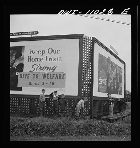 Untitled photo, possibly related to: Lititz (vicinity), Pennsylvania. Boys playing near a billboard. Most of their fathers work in nearby defense plants