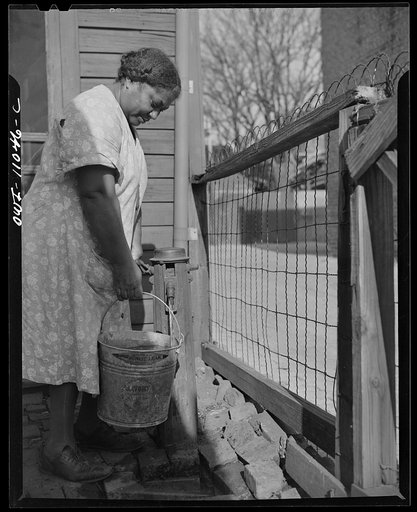 Washington (southwest section), D.C. Negro woman drawing water from an outdoor hydrant