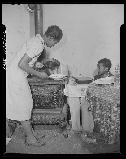 Washington (southwest section), D.C. A mother preparing dinner in a one-room flat