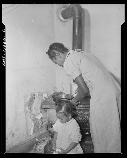 Washington (southwest section), D.C. A mother preparing dinner in a one-room flat