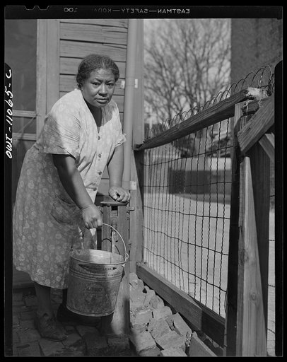 Washington (southwest section), D.C. Negro woman drawing water from an outdoor hydrant