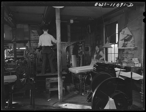 Lititz, Pennsylvania. Press room of the Lititz Record-express. Publisher Young waits for a bunch of papers to come off the press so that he can take them into the cutting and folding machine