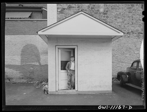 Lancaster, Pennsylvania. Parking lot. Mural painting at left shows a tramp fishing by a stream