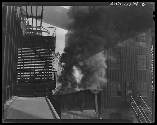 Hanna furnaces of the Great Lakes Steel Corporation. Detroit, Michigan. Coke being pushed out of coke ovens into specially constructed freight cars