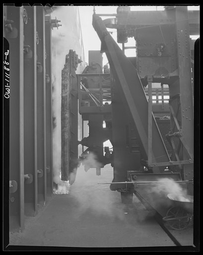 Hanna furnaces of the Great Lakes Steel Corporation. Detroit, Michigan. Removing the door of the coke oven so that pusher can be inserted into one of the sections