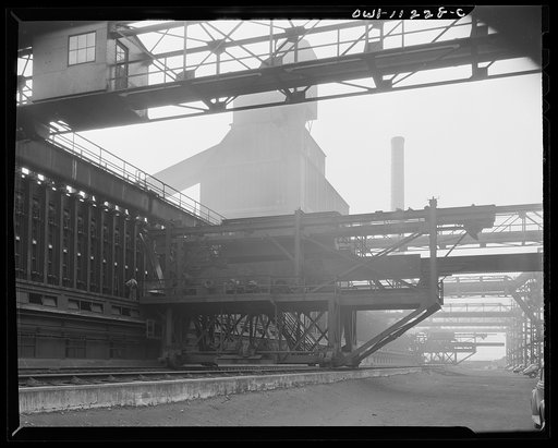 Hanna furnaces of the Great Lakes Steel Corporation. Detroit, Michigan. Coke pusher apparatus with coal storage building seen in the fog which constantly hangs over the place