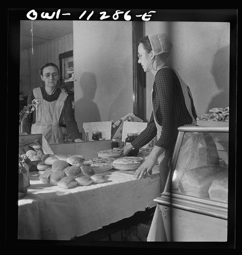 Lititz, Pennsylvania. Mennonite woman arranging baked goods at the farmers' market