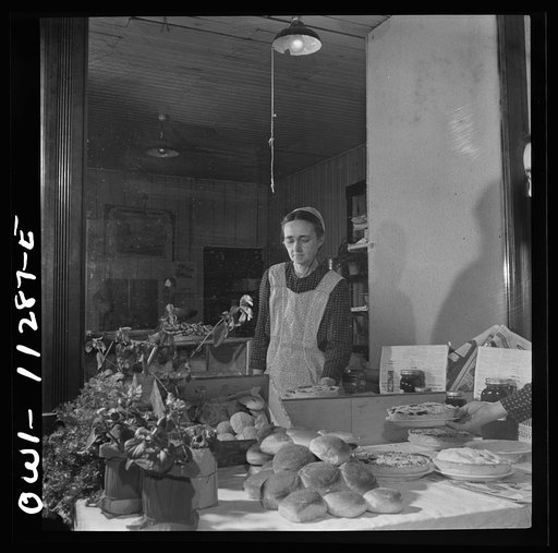 Lititz, Pennsylvania. Mennonite woman arranging baked goods at the farmers' market