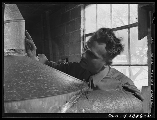 Untitled photo, possibly related to: Lititz, Pennsylvania. Machine shop back of Morris Kreider's hardware store where he makes small parts for neighboring defense plants. Here he is working on a "cyclone" or dust collector for the Hackman Furniture Company, now making propellors. Kreider expects his