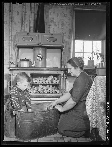 Untitled photo, possibly related to: Lititz, Pennsylvania. Mennonite farmer's wife and her son husking corn which has been dried out in the oven. It will then be taken to a mill to be ground for cornmeal