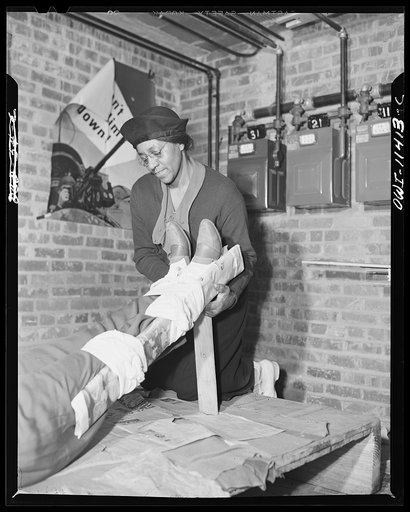 Washington, D.C. First aid class of the air raid warden unit in the Southwest area. An elderly member of the first aid class adjusting the legs to the proper position after applying splint