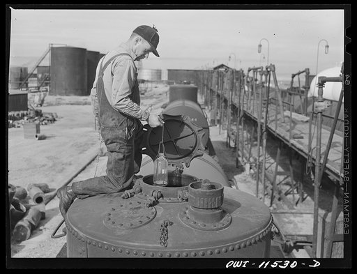 Phillips gasoline plant. Borger, Texas. Taking a sample of gasoline from a loaded tank car