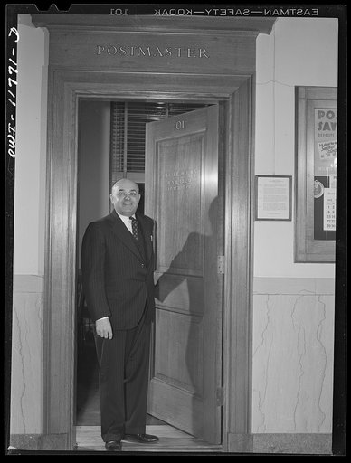 Lititz, Pennsylvania. Postmaster Robert Pautz chatting with two friends in the post office. He has three sons and one son-in-law in the service, and his daughter works in the U.S. War Department, so he has every reason to push the sale of war bonds. He plasters his post office with every available p