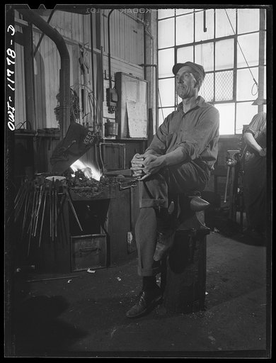 Lititz, Pennsylvania. Ellis Spickler has been working at the Animal Trap Company since 1909; he finds a blacksmith's forge the best way to harden and temper setting tools
