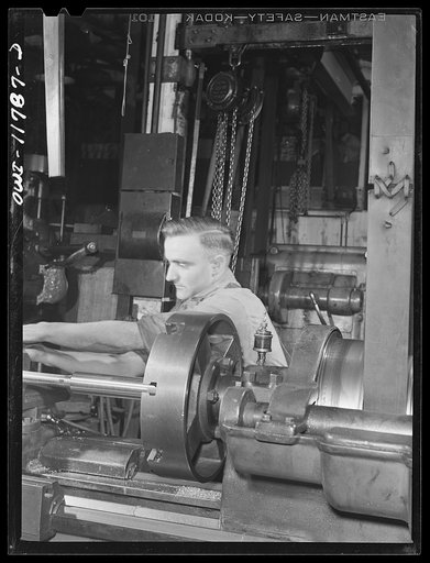 Untitled photo, possibly related to: Lititz, Pennsylvania. Raymond Newswanger works a lathe in the Animal Trap Company machine shop. He's a Mennonite, about thirty, and hopes his church won't find out he's doing defense work. Most Mennonites are farmers, and Newswanger used to be