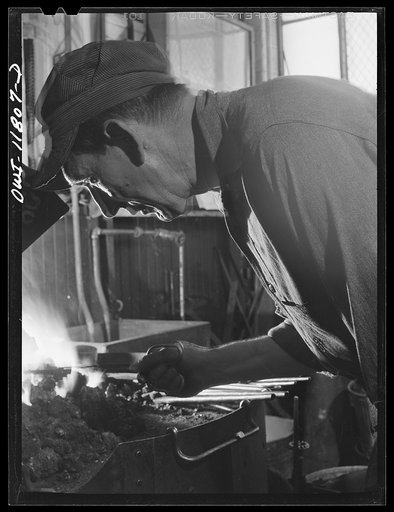 Untitled photo, possibly related to: Lititz, Pennsylvania. Ellis Spickler has been working at the Animal Trap Company since 1909; he finds a blacksmith's forge the best way to harden and temper setting tools