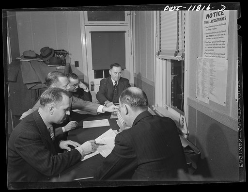 Ephrata, Lancaster County, Pennsylvania. Draft Board Number 5 which takes care of Lititz cases along with neighboring towns. Left to right: back to camera, John L. Bowman, attorney; George C. Ballman (secretary), hat manufacturer; Harold Shirker, full time clerk; W.E. Buchholder (chairman), Justice 