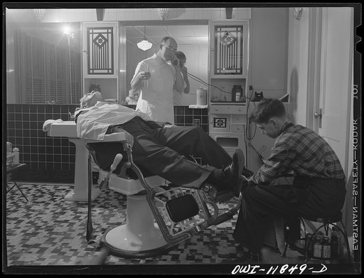Lititz, Pennsylvania. Mr. Pennepacker, one of seven barbers in town, has sixty less haircuts a month since the boys left town