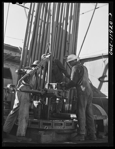 Andrews County, Texas. Attaching clamps to piece of drill pipe which will be hoisted out of hole
