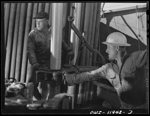 Andrews County, Texas. Attaching clamps to a section of drill pipe