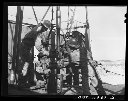 Untitled photo, possibly related to: Andrews County, Texas. Attaching new bit to the drill pipe