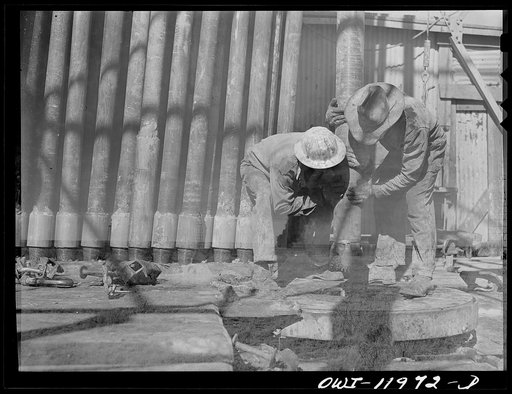 Untitled photo, possibly related to: Amdrews County, Texas. Roughnecks reaching for descending traveling block during pipe pulling operations