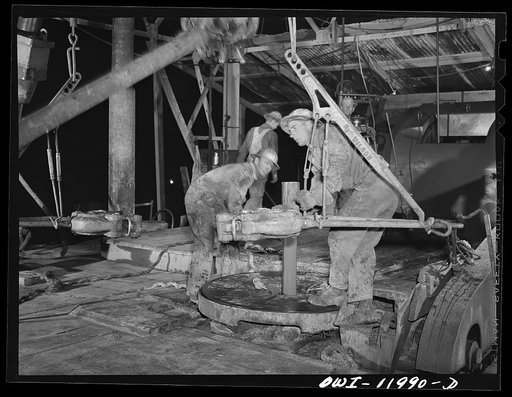 Untitled photo, possibly related to: Andrews County, Texas. Preparing to add a new section of pipe on night tour