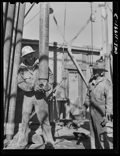Untitled photo, possibly related to: Andrews County, Texas. Attaching new bit to the drill pipe