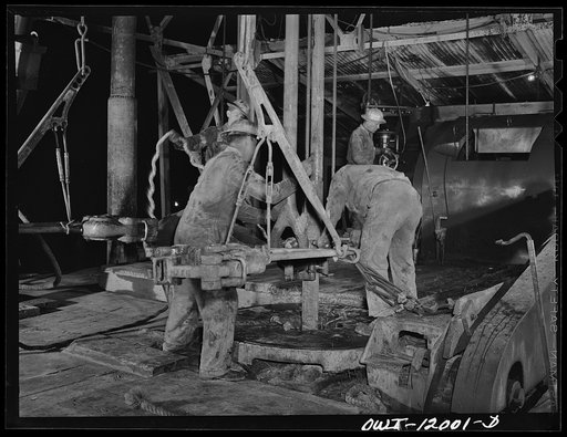 Andrews County, Texas. Preparing to add a new section of pipe on night tour