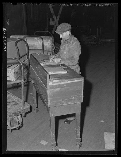Chicago, Illinois. A checker working at his portable table. These tables are moved about from car to car as each is loaded in the freight house at a Chicago and Northwestern Railroad yard