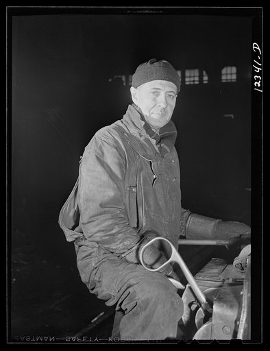 Chicago, Illinois. A workman at the roundhouse who operates a small derrick used for lifting heavy parts for locomotive repair at a Chicago and Northwestern Railroad yard