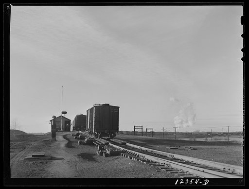 Chicago, Illinois. A "cut" going over the hump at a Chicago and Northwestern Railroad yard. The smoke in the background is from the engine pushing these cars