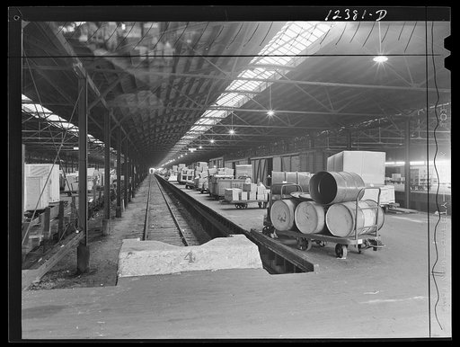 Chicago, Illinois. Goods of every description lined up on loading platforms at a freight house at a Chicago and Northwestern Railroad yard