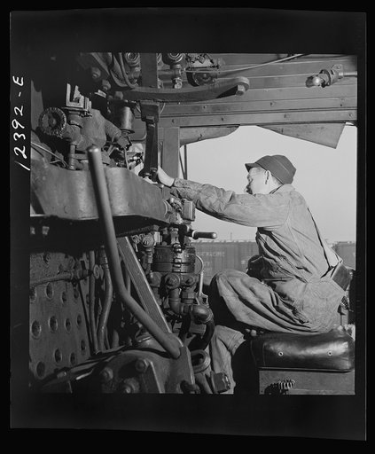 Chicago, Illinois. Engineer of an incoming locomotive in his cab at a Chicago and Northwestern Railroad yard