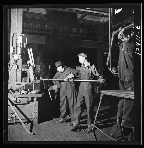 Chicago, Illinois. Workers bending a pipe for the repair of a locomotive at the Chicago and Northwestern Railroad shops