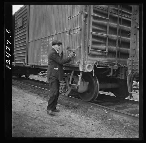 Untitled photo, possibly related to: Chicago, Illinois. Car checker writing instructions in chalk for special handling of cars going over the hump at a Chicago and Northwestern Railroad yard