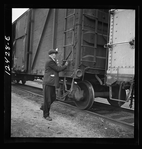 Untitled photo, possibly related to: Chicago, Illinois. Car checker writing instructions in chalk for special handling of cars going over the hump at a Chicago and Northwestern Railroad yard