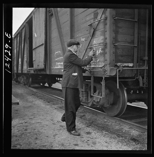Chicago, Illinois. Car checker writing instructions in chalk for special handling of cars going over the hump at a Chicago and Northwestern Railroad yard