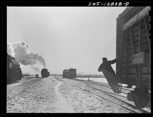 Chicago, Illinois. Switchman riding a car in a Chicago and Northwestern Railroad classification yard