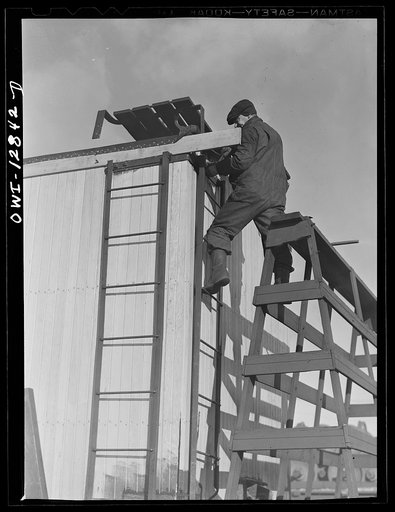 Chicago, Illinois. Carpenter working on a car being rebuilt at the rip tracks at a Chicago and Northwestern Railroad