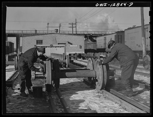 Chicago, Illinois. Painting grease on the bearings of new car wheels just arrived from the shops at the Chicago and Northwestern Railroad rip tracks