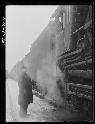 Chicago, Illinois. Conductor John L. Walter comparing time with his engineer before leaving a Chicago and Northwestern Railroad yard for Clinton, Iowa