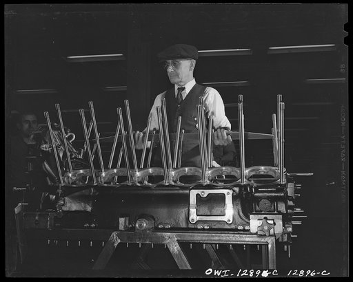 Detroit, Michigan. Assembly of Rolls Royce engines at the Packard motor car company. Checking alignment of the studs