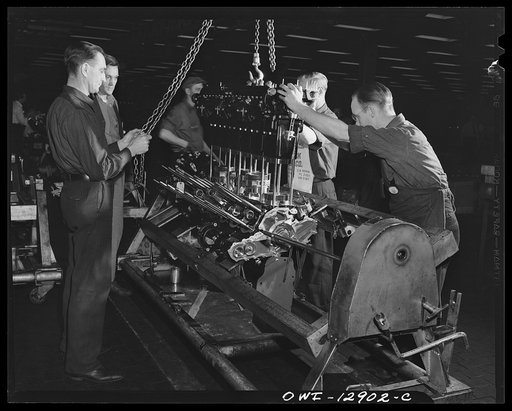 Detroit, Michigan. Assembly of Rolls Royce engines at the Packard motor car company. Dropping a cylinder bank on an upper crankcase