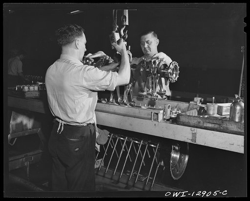 Detroit, Michigan. Assembly of Rolls Royce engines at the Packard motor car company. Dropping the assembly into the upper crankcase