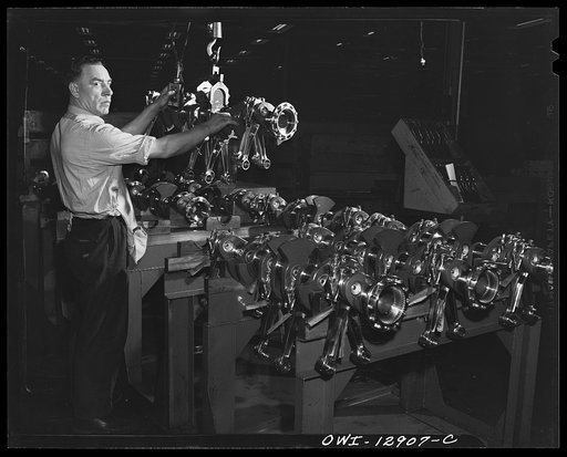 Detroit, Michigan. Assembly of Rolls Royce engines at the Packard motor car company. Group of connecting rods going into the crankshaft