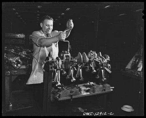 Detroit, Michigan. Assembly of Rolls Royce engines at the Packard motor car company. Assembling connecting rods on a crankshaft
